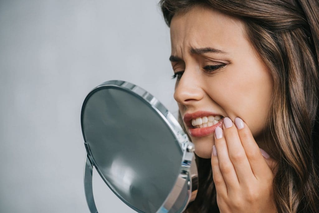 Women looking at teeth in mirror