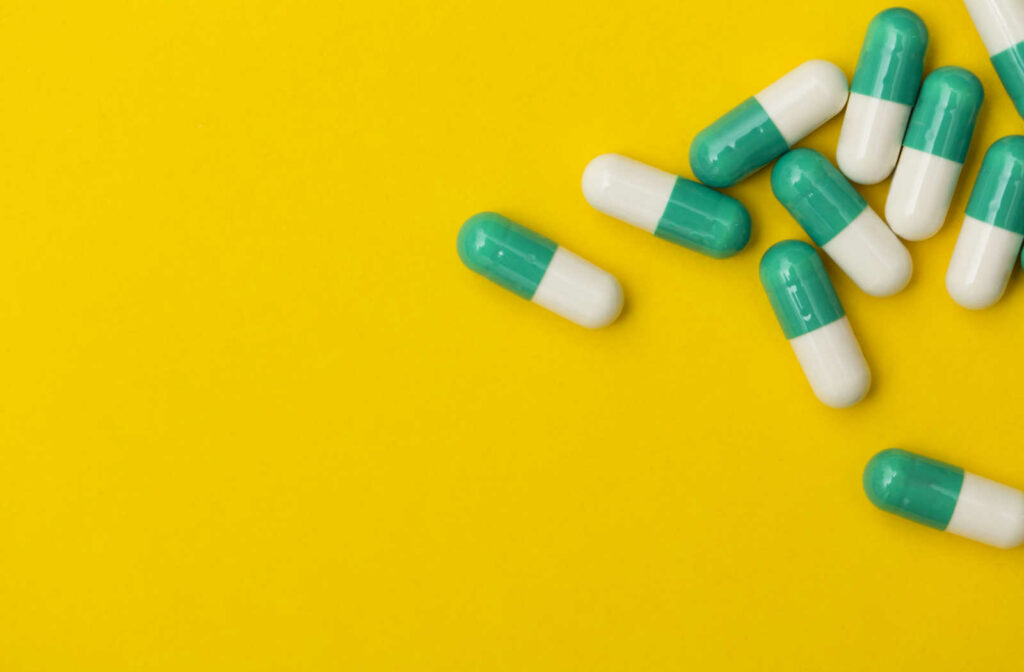 Antibiotic pills on a yellow background.