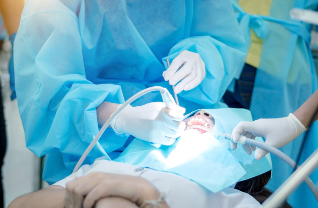 Patient at the dental surgeons clinic during a procedure wearing an isolation cover for the face.